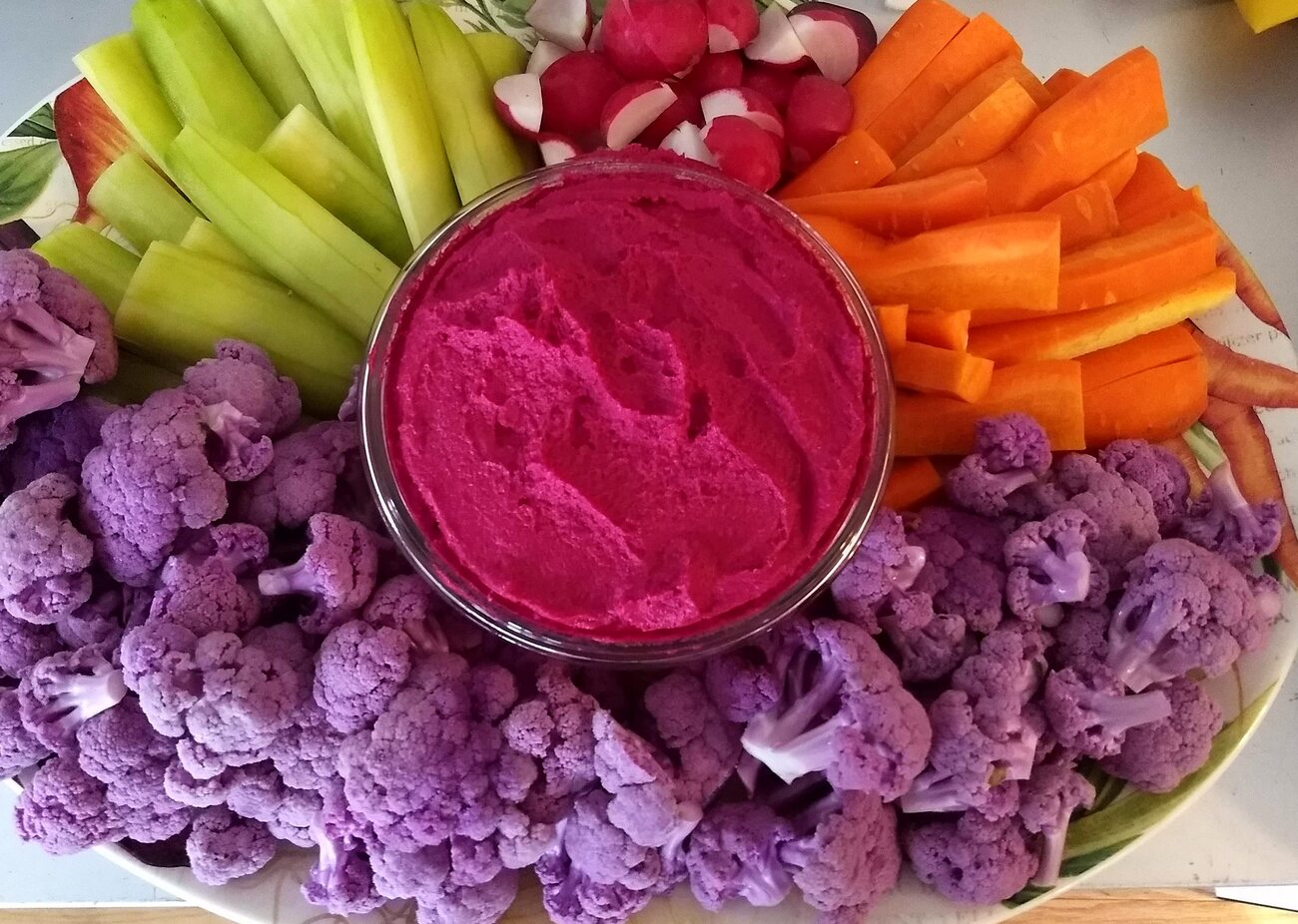 Beet hummus with purple cauliflower, carrots, and cucumber