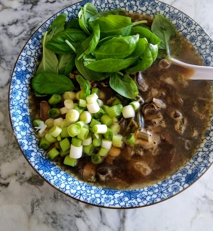 Herb soup topped with fresh basil and scallions